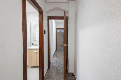 a hallway with a bathroom with a sink and a mirror at Cómodo apartamento cerca del metro y de la feria Valencia in Paterna
