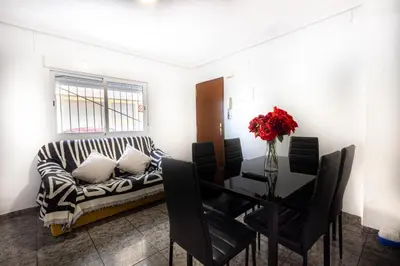 a living room with a couch and a dining room table at Cómodo apartamento cerca del metro y de la feria Valencia in Paterna