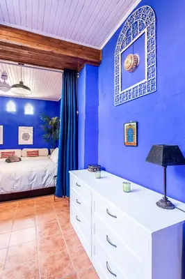 a blue bedroom with a bed and a white dresser at Romantic Mediterranean Riad in Tavernes de Valldigna