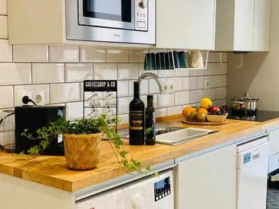 a kitchen counter with bottles of wine and fruits at Beautiful modern loft 1km from the sea in Valencia in Valencia
