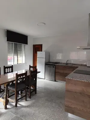 a kitchen with a table and chairs and a refrigerator at La Casa de los Alemanes in Gaibiel