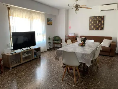 a living room with a table and a television at Plaza Mare Nostrum 5 min playa in Puerto de Sagunto