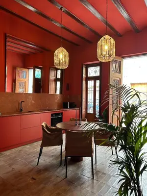 a kitchen with red walls and a table and chairs at Apartamento de diseño a 500 metros de la playa in Valencia