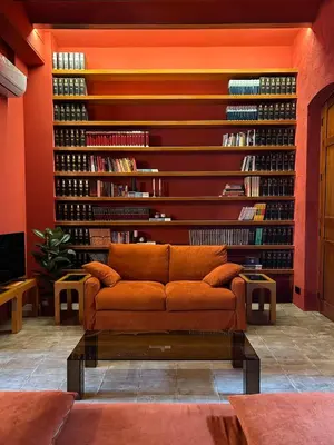 a living room with a couch in front of a wall of books at Apartamento de diseño a 500 metros de la playa in Valencia