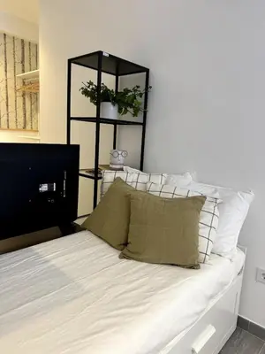 a bedroom with a bed with white sheets and a black shelf at Loft in Valencia, equipped and very well decorated in Valencia