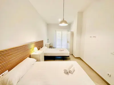a white bedroom with two beds and a window at Filologo Sanelo Luxury Apartaments in Valencia