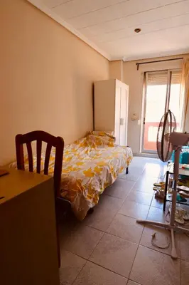 a bedroom with a bed in a room with a table at 2 Bed Apartment, Great Location, 500M from Beach in Valencia
