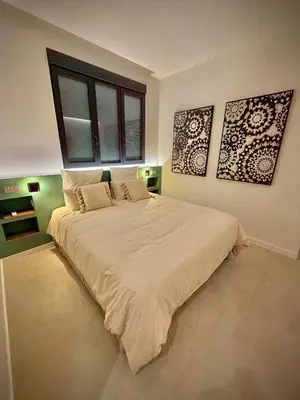 a bedroom with a large bed with two pictures on the wall at Luxury apartment in Cabanyal in Valencia