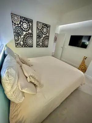 a bedroom with a bed with white sheets and pillows at Luxury apartment in Cabanyal in Valencia