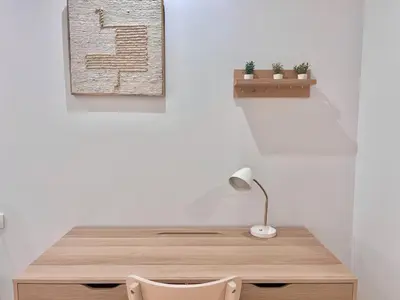 a desk with a lamp and a plant on a wall at Apartamento Mare Nostrum in Valencia