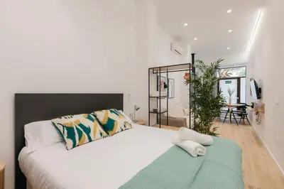 a bedroom with a white bed with a green rug at Design loft in Valencia in Valencia