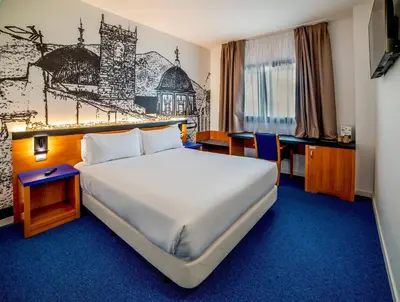 a hotel room with a large bed and a desk at Hotel Sercotel Plana Onda in Onda