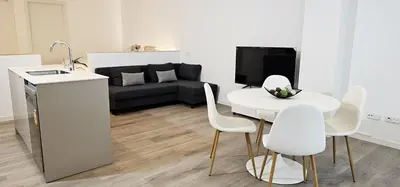 a living room with a white table and white chairs at Vacansis Masamagrell Bajo Loft Tomas y Valiente in Masamagrell