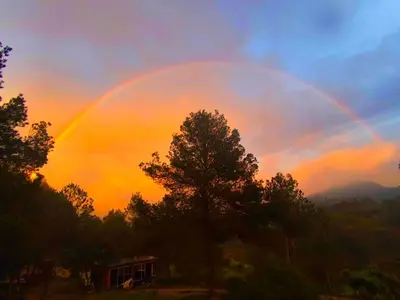 a rainbow in the sky with a house and trees at Beautiful mountain chalet in Siete Aguas