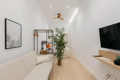 a white living room with a white couch and a tv at Elegant Loft in Valencia in Valencia