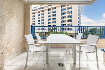 a white table and chairs on a balcony with a building at ApartUP Patacona Iconic I in Valencia