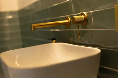 a white sink in a bathroom with a gold faucet at Apartamento 4 Pax Vistas Torres de Serrano in Valencia