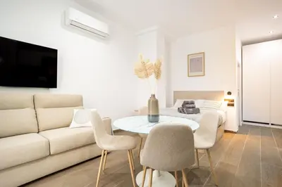 a living room with a couch and a table and chairs at Valencia Central Flats - Exclusiva, junto al Roig Arena in Valencia