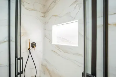a shower with marble walls and a glass door at Valencia Central Flats-Moderno, junto al Roig Arena in Valencia