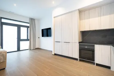 a large kitchen with wooden cabinets and a television at Valencia Central Flats-Moderno, junto al Roig Arena in Valencia