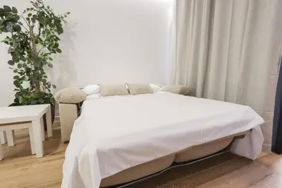 a bedroom with a white bed and a plant at ADapartments in Valencia