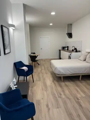 a bedroom with a bed and a blue chair at Valencia City Scapes in Valencia