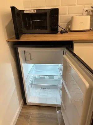 an empty refrigerator with a microwave on a counter at Valencia City Scapes in Valencia