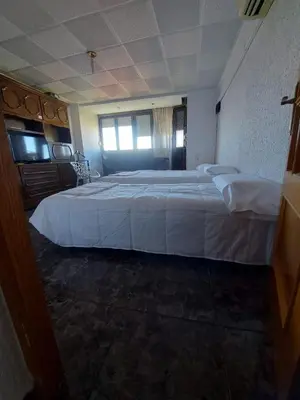 a bedroom with a large bed with white sheets at Reina Beach House in Valencia