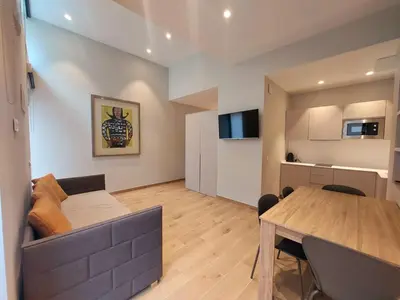 a living room with a couch and a dining room table at Fitness & Spa, Suite Atalanta Valencia in Valencia