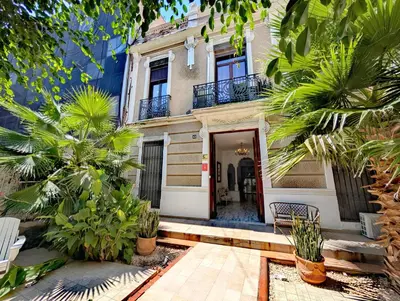 a house with a wooden door and some palm trees at Portrait Boutique Villa in Valencia