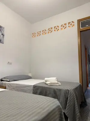two beds in a white room with towels on them at Brisa de mar in El Perelló