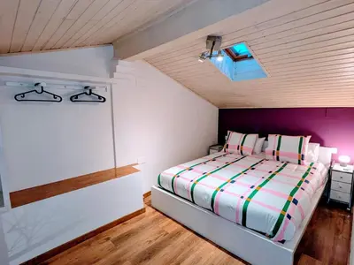 a bedroom with a bed with a purple and white comforter at Padre Luis flat in Valencia