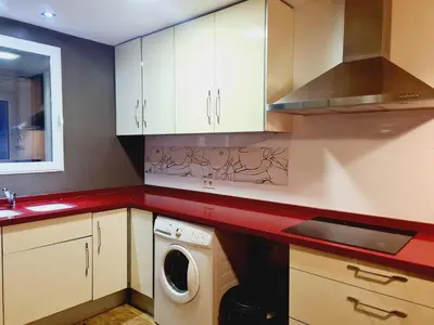 a kitchen with white cabinets and a washing machine at Padre Luis flat in Valencia