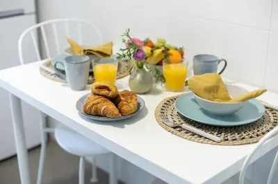 a table with two plates of croissants and orange juice at El Cabañal - Familiar in Valencia