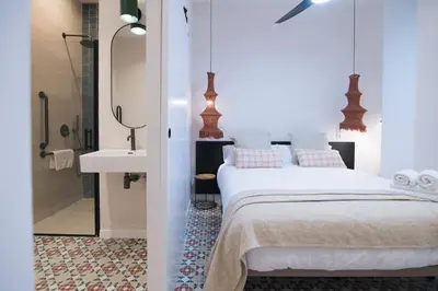 a bedroom with a bed and a bathroom with a sink at District Key - Valencia, Fuencaliente D in Valencia