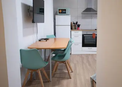 a kitchen with a wooden table and two chairs at LOWCOST Beach & CityCenter in Valencia