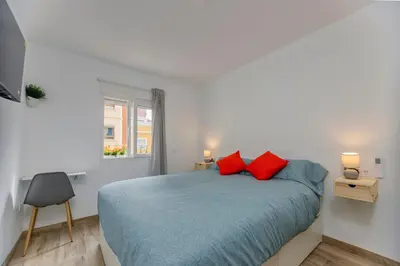 a bedroom with a bed with two red pillows at Malva Playa in Valencia