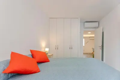 a bedroom with a bed with two orange pillows at Malva Playa in Valencia