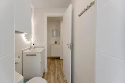 a white bathroom with a toilet and a sink at Malva Playa in Valencia