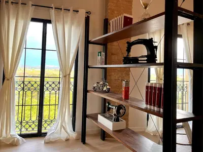 a room with a book shelf and a large window at Luminoso loft boutique a 5 min del metro in Bétera