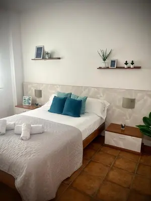 a bedroom with a large white bed with blue pillows at Mar in Valencia