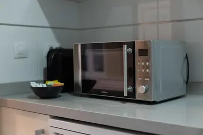 a microwave sitting on a counter in a kitchen at Dorm4You Patacona in Valencia