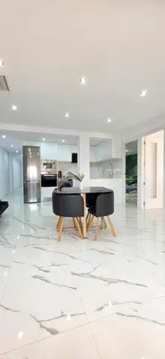 a white living room with two black chairs and a table at Paradise Home in Valencia