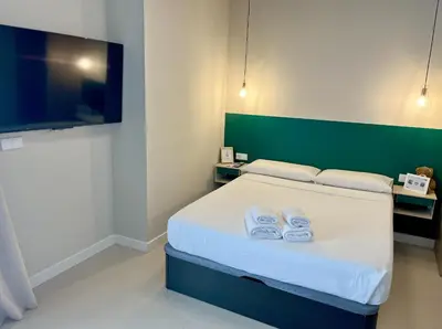 a bedroom with a bed with two towels on it at Osito Hub - Colomer in Valencia