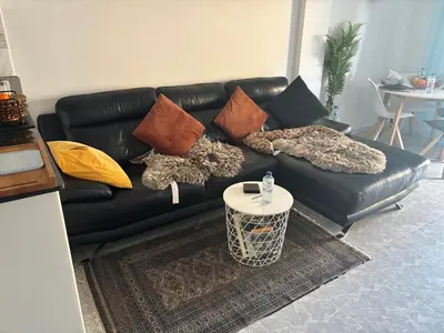 a black leather couch with pillows and a table at Wohnung in Moncófar