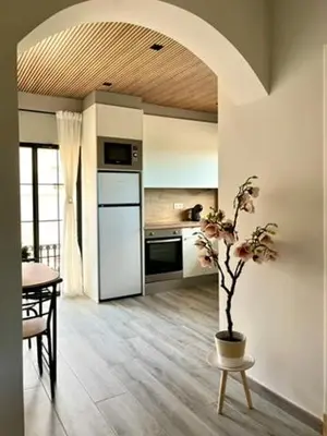 a kitchen with a table and a vase with a plant at Elegante apartamento boutique a 5 min del metro in Bétera