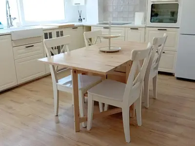 a kitchen with a wooden table and white chairs at Casa El Azud La Cañada 1 minuto metro in Partida de La Cañada