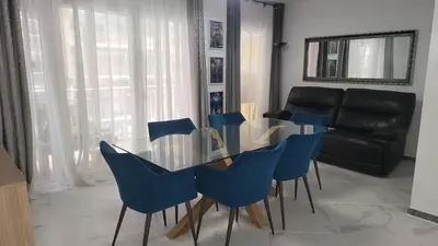 a dining room with a glass table and blue chairs at Medusa Felix in Cullera