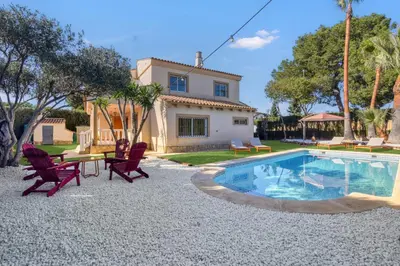 a backyard with a pool and chairs and a house at Private Garden Villa near Valencia with Cinema and Gym in La Eliana