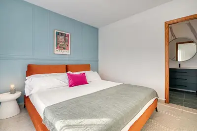 a bedroom with a large bed with a pink pillow at Private Garden Villa near Valencia with Cinema and Gym in La Eliana